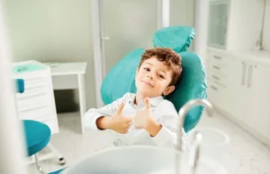 Nen al silló del dentista somrient en una revisió d’apinyament dental